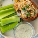 buffalo chicken stuffed sweet potatoes with ranch dressing and celery sticks