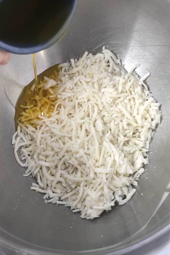 pouring ghee into hash browns