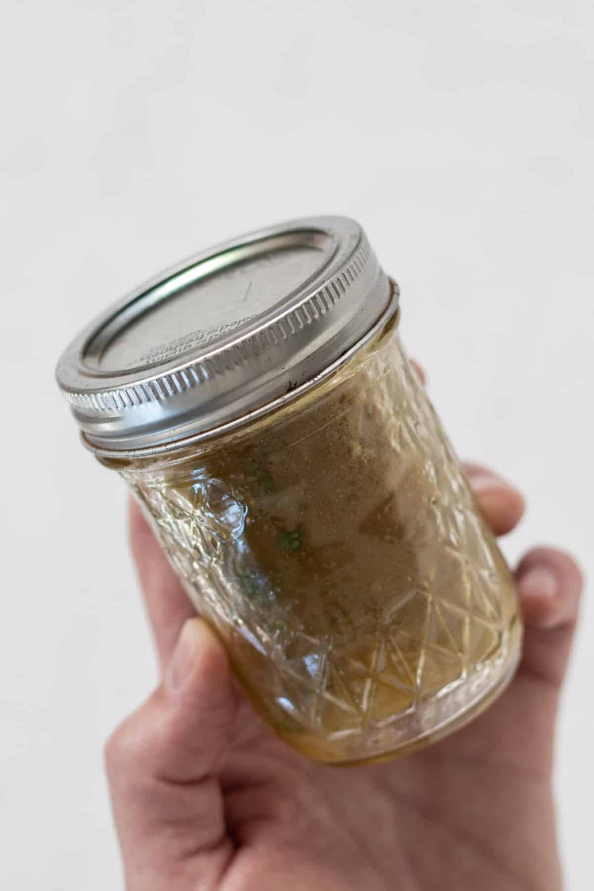 Using a mason jar to shake white balsamic dressing.