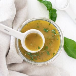 Overhead picture of white balsamic dressing in a glass jar with a spoon.