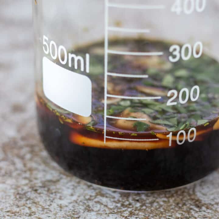 glass jar filled with balsamic vinegar, herbs, and garlic