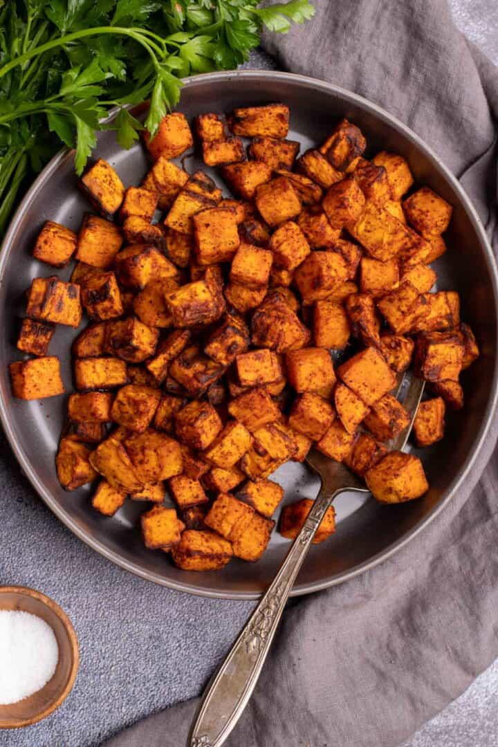 Sweet potato cubes in a bowl with a fork.