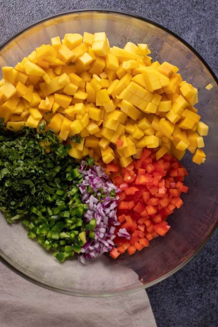 mango salsa ingredients chopped up and placed into a large mixing bowl.