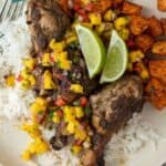 jerk chicken on a dinner plate with rice and sweet potatoes