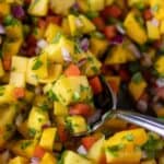 mango salsa with serving spoon.