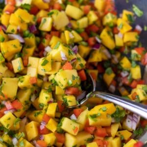 mango salsa in a large bowl with a serving spoon