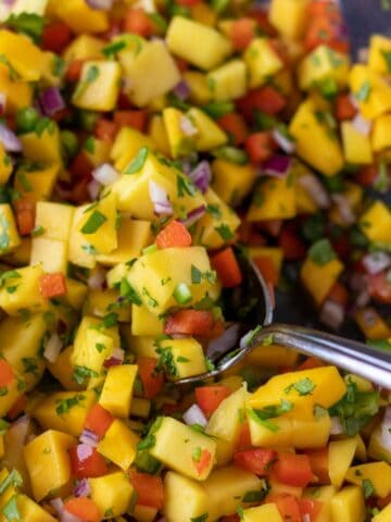 mango salsa in a large bowl with a serving spoon