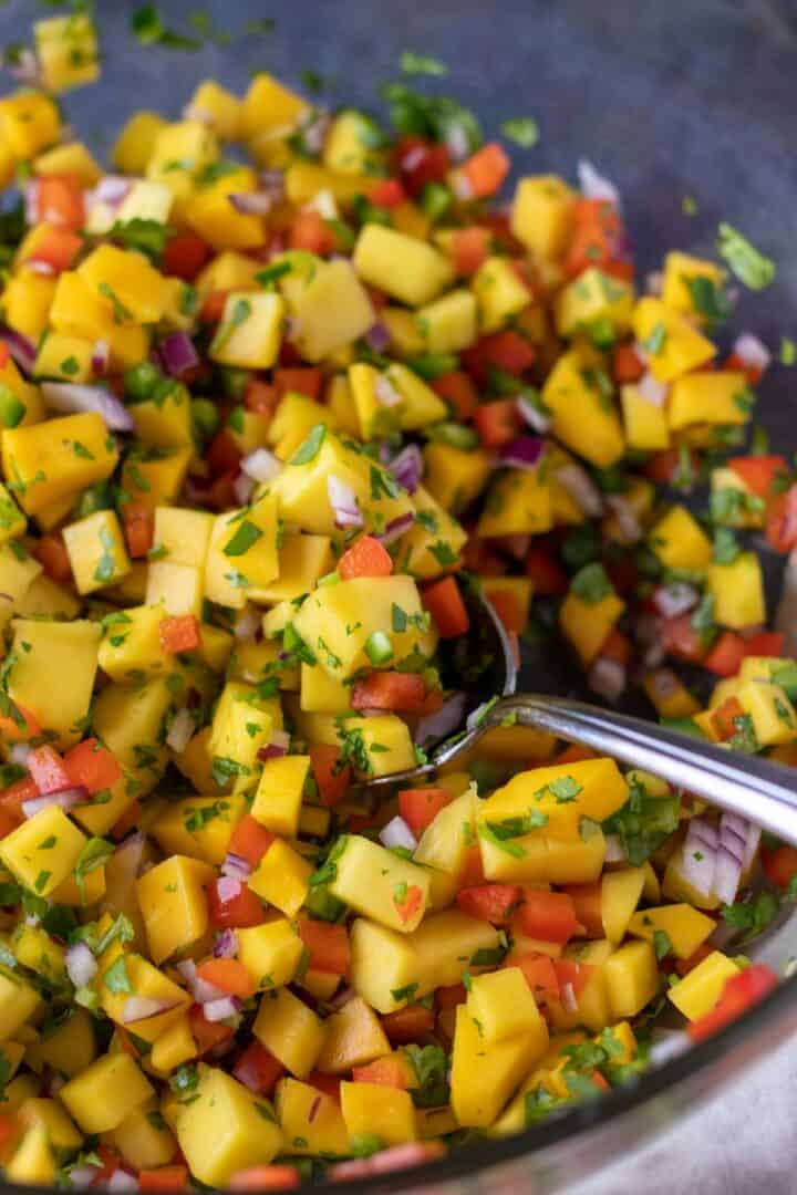 mango salsa in a large bowl with a spoon