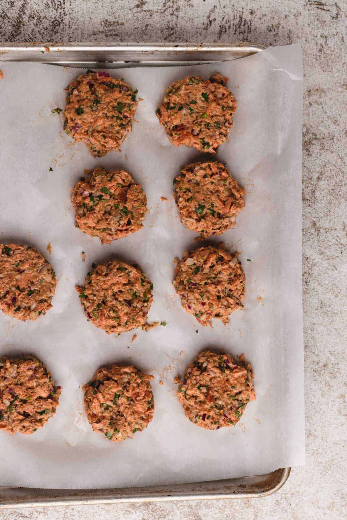 Formed salmon cakes on baking tray.