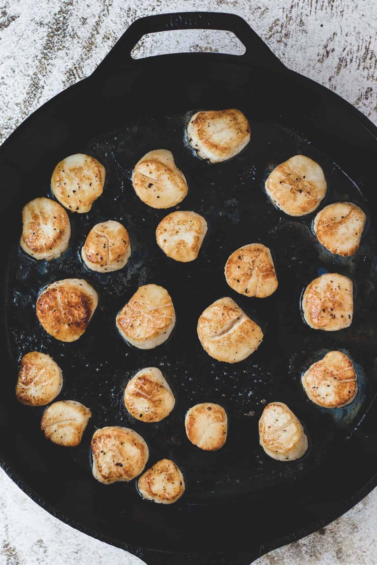 Searing scallops in a cast-iron pan.