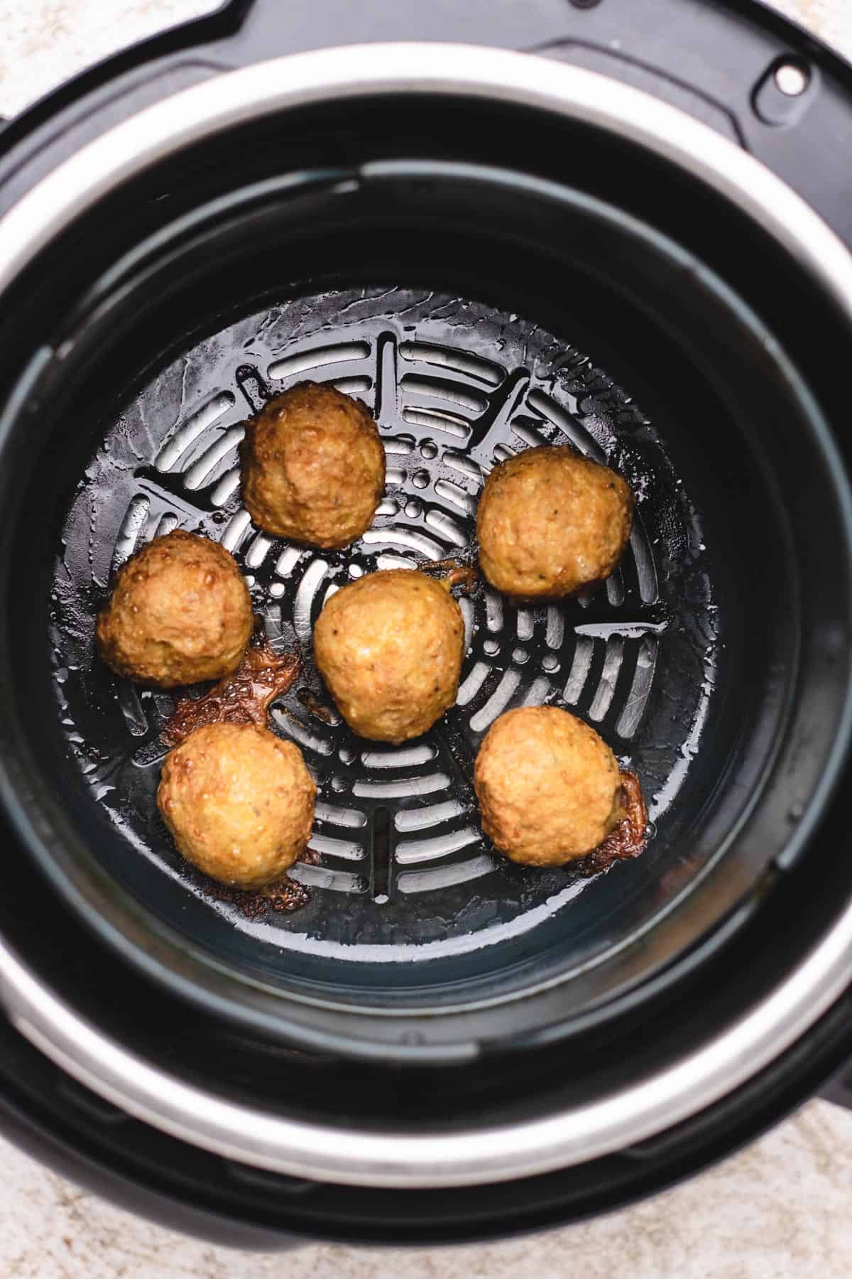 Meatballs inside of air fryer.