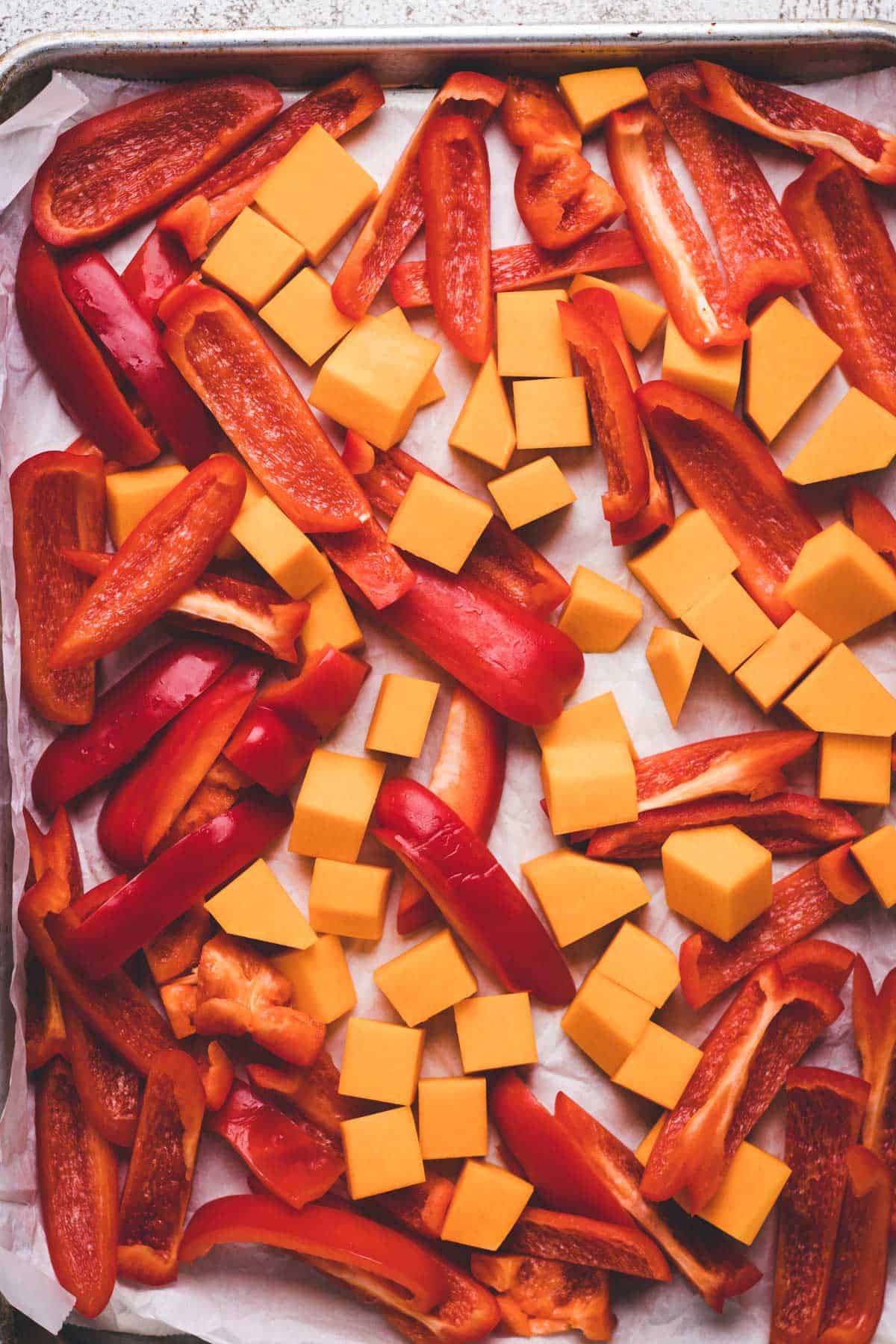 Roasting butternut squash and red peppers on baking tray.