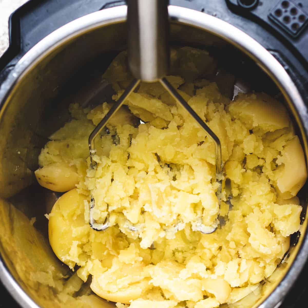 Mashing yukon gold potatoes.
