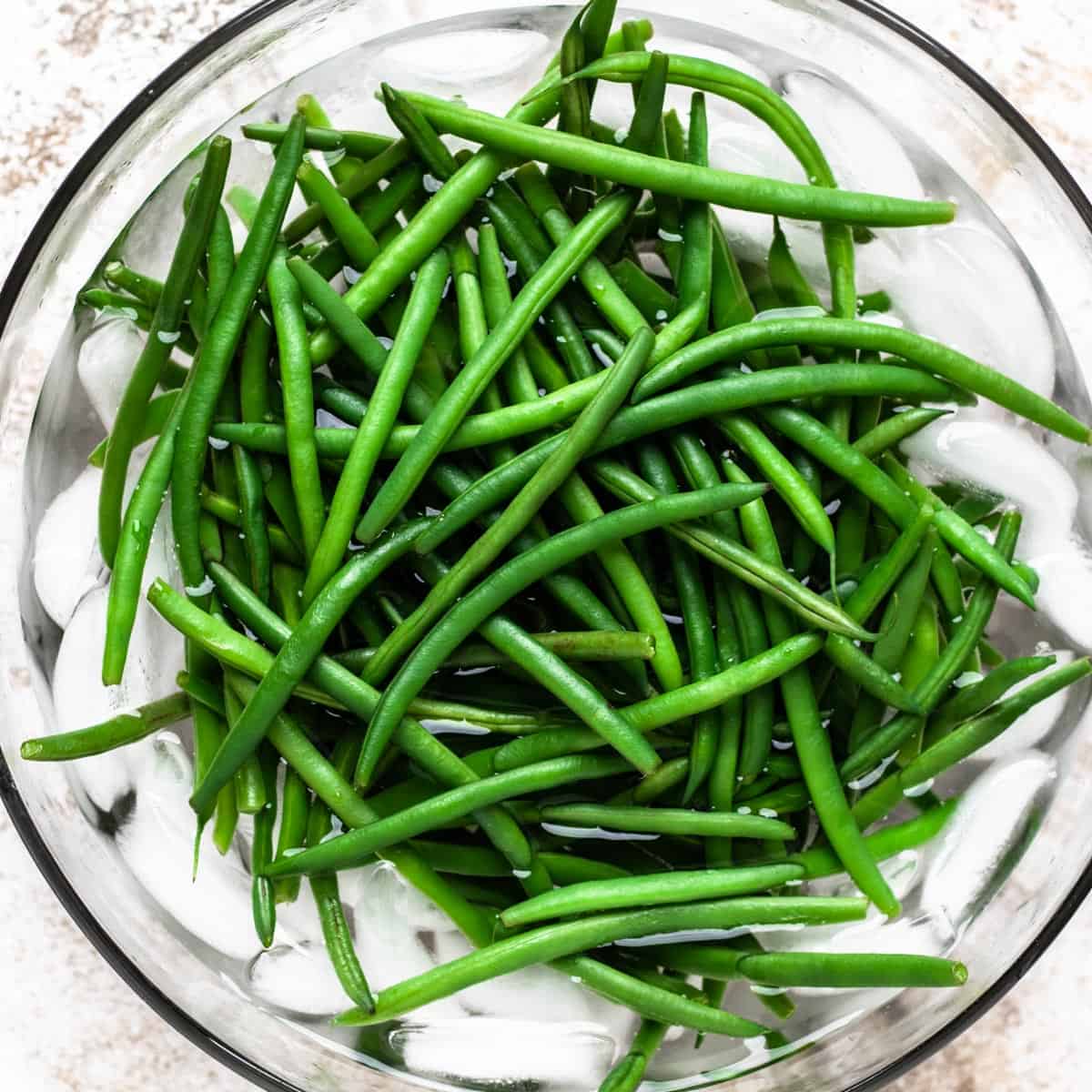 Green beans in a bowl of ice water.