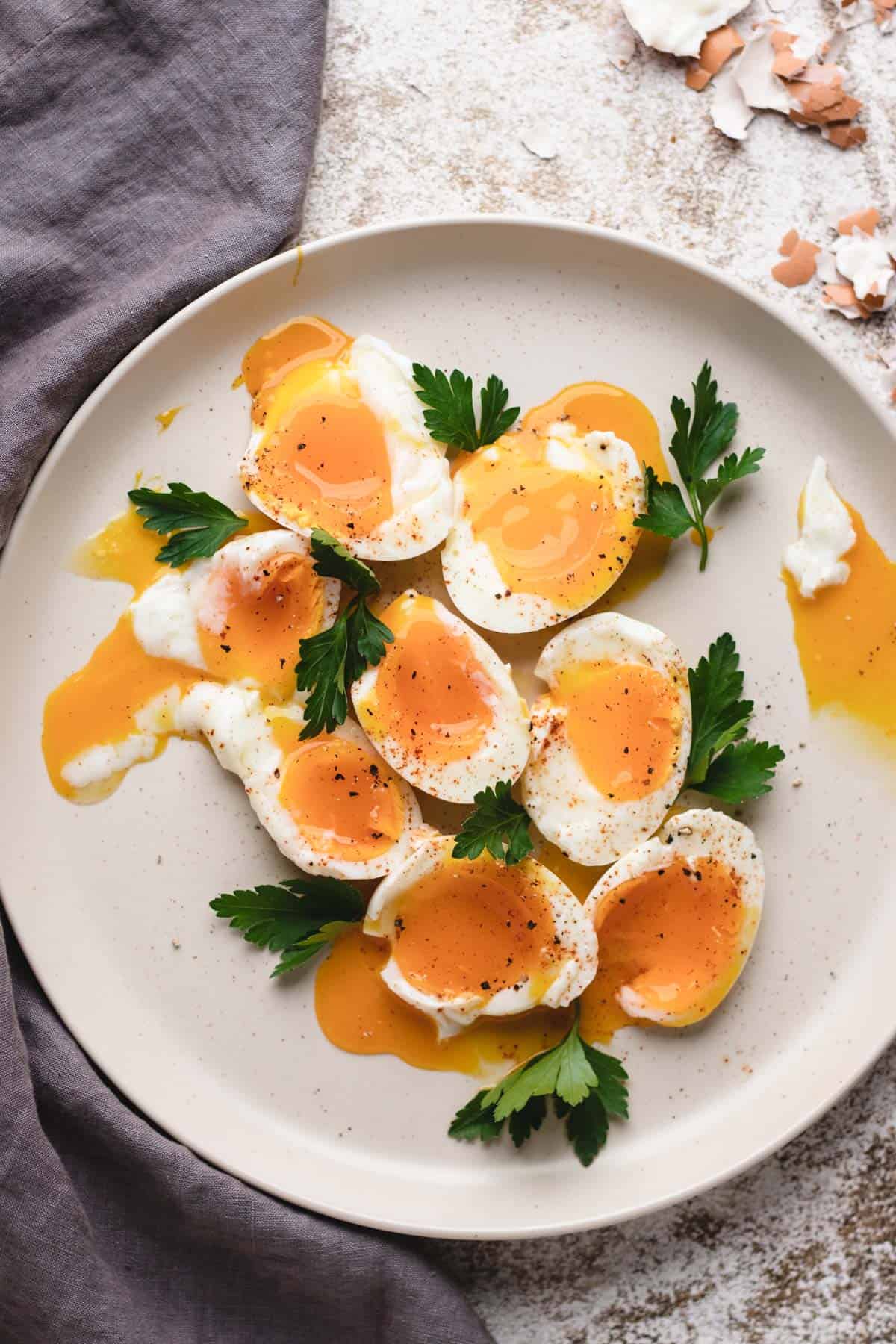 Soft-boiled eggs cut in half on a large plate.