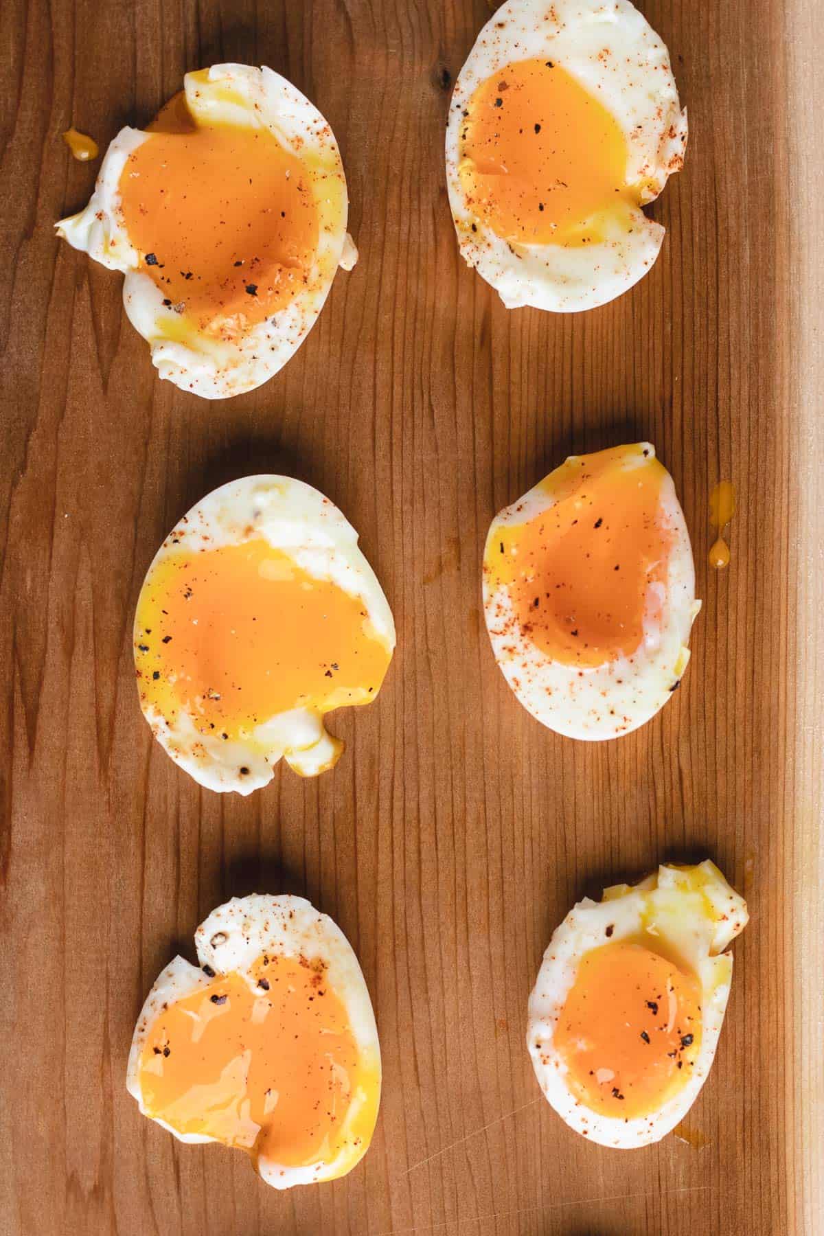 Air fryer soft-boiled eggs on a wooden plank.
