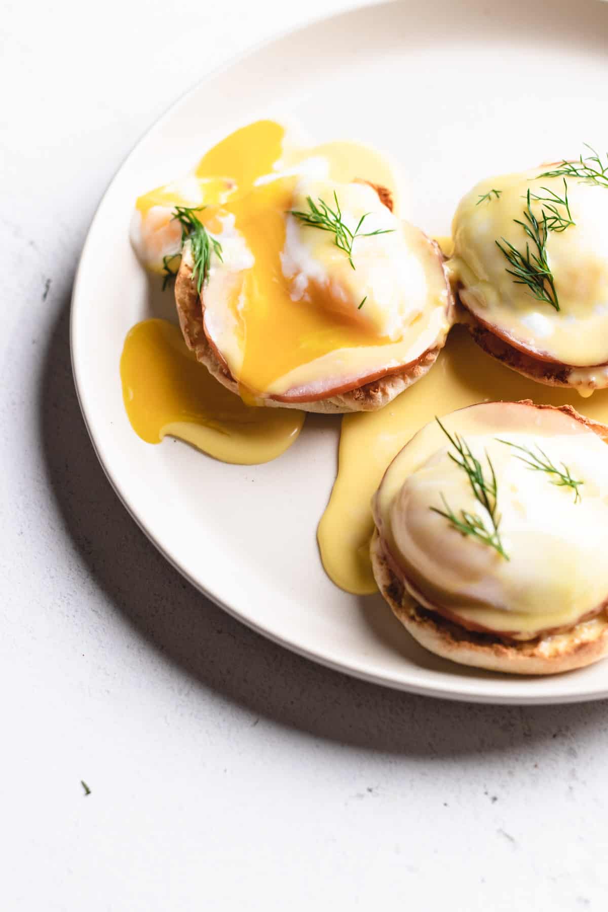 Close up photo of eggs benedict with a broken yolk.