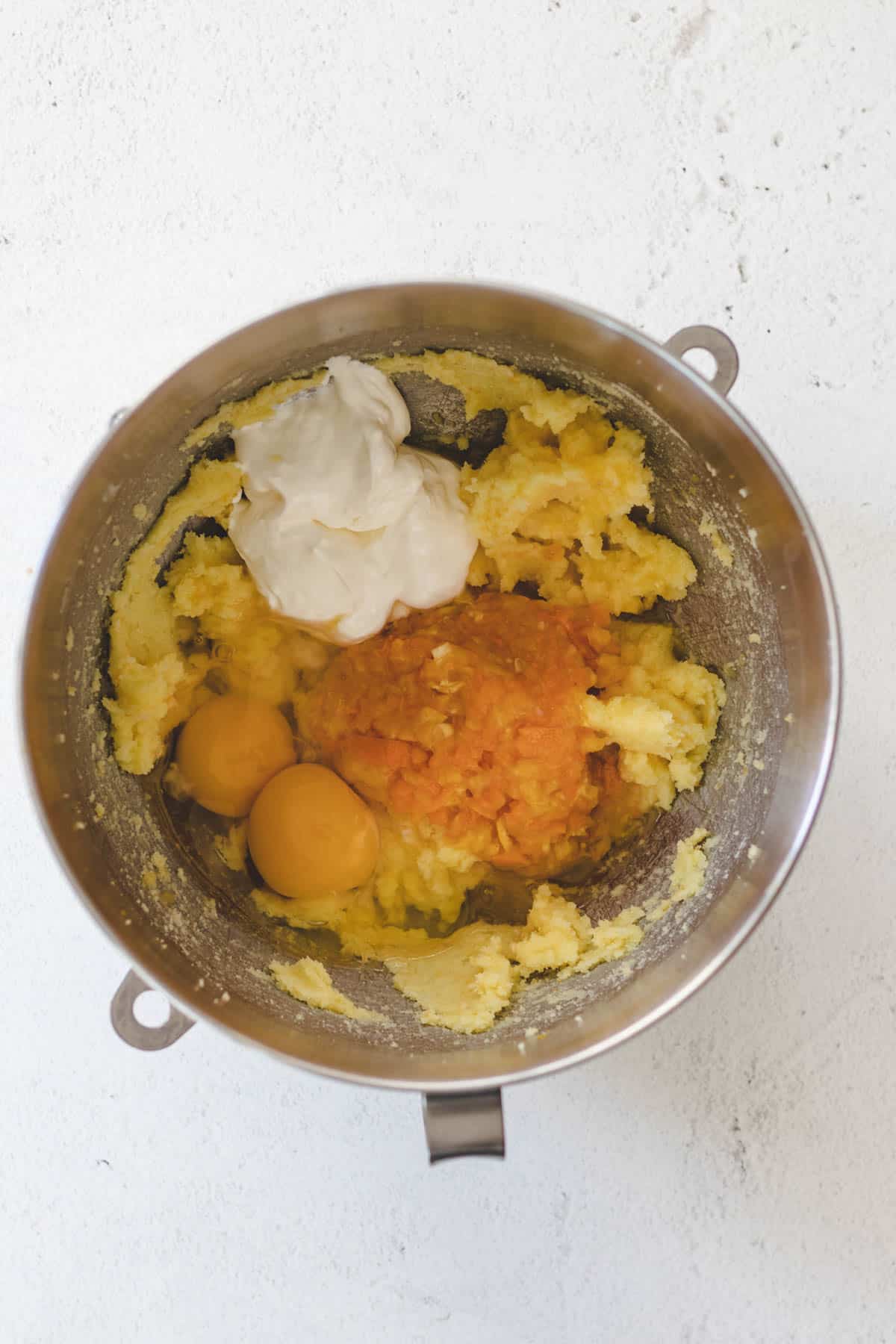 Beating kumquats, eggs, and sour cream into the batter.