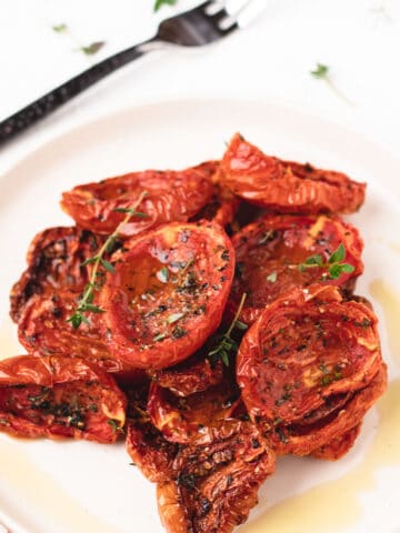 A featured image of air fryer slow roasted tomatoes on a small plate.