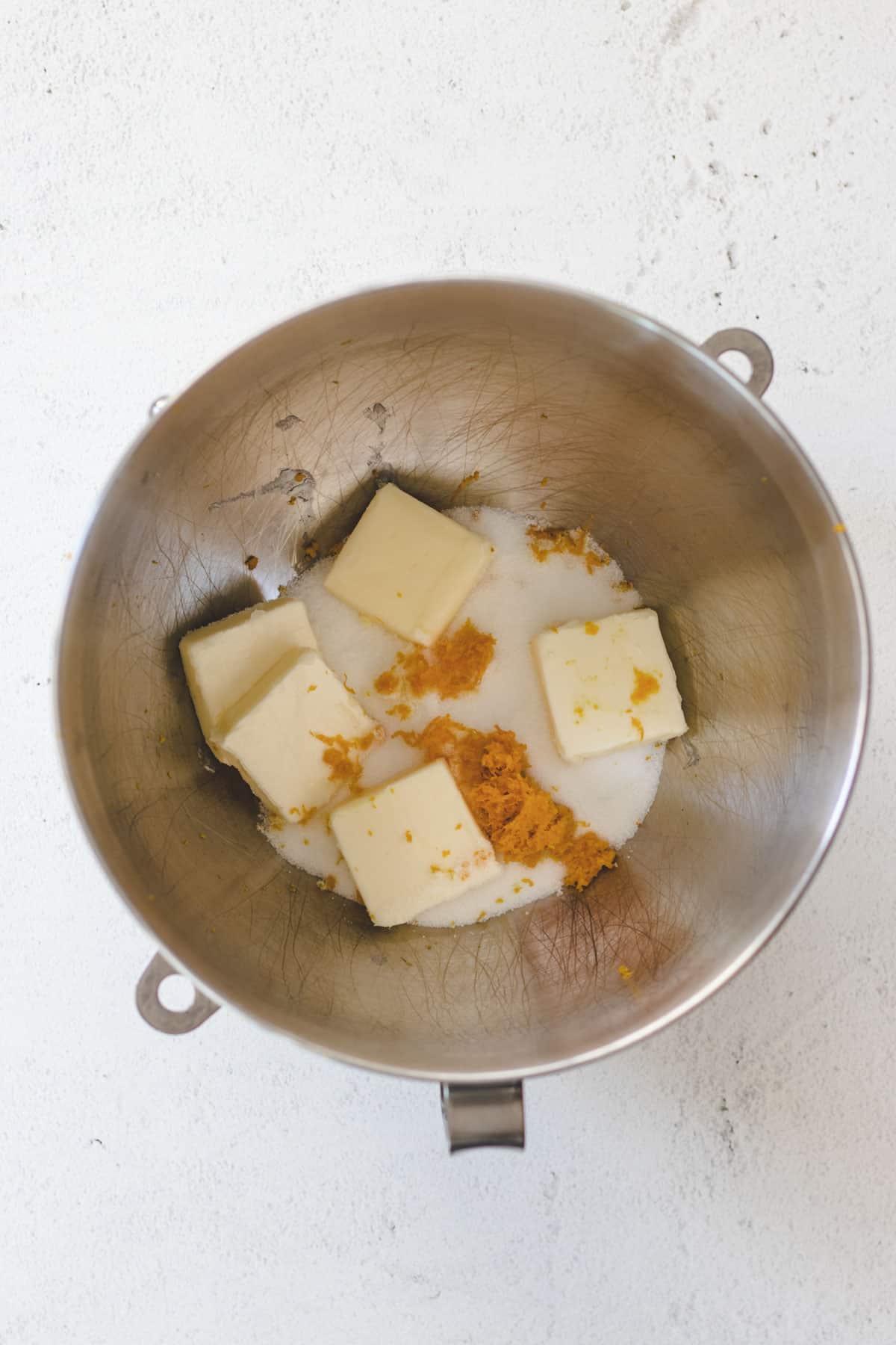 Creaming butter, sugar, and orange zest in a mixing bowl.