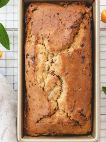 Picture of a baked gluten-free fruit loaf inside of a rectangle loaf pan.