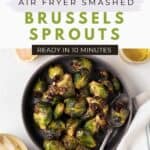Air fried Brussels sprouts in a round dark grey bowl with a spoon.