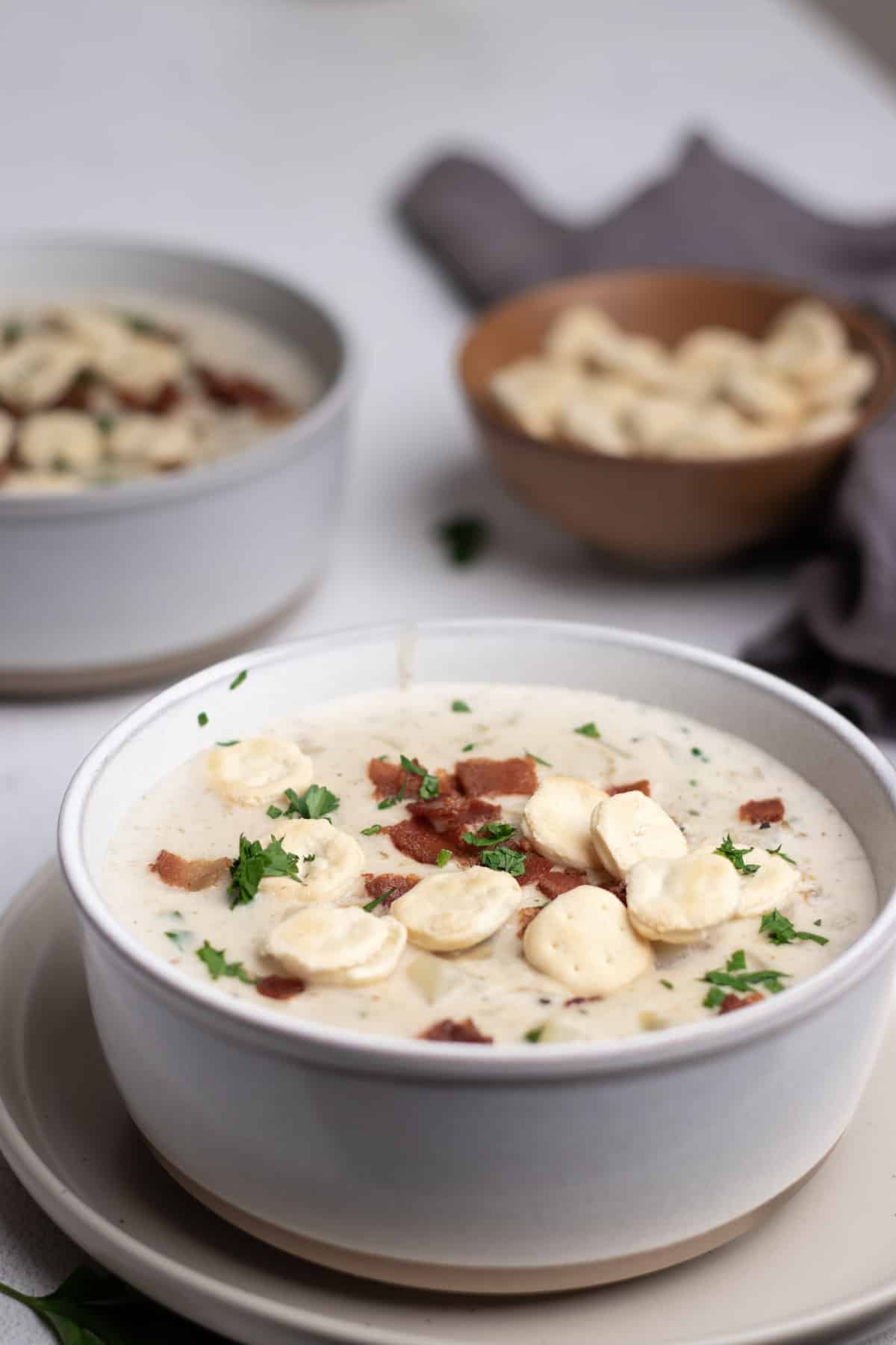 Instant pot clam chowder inside of two soup bowls with oyster crackers.