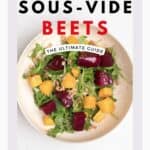 Red and yellow beets on a bed of arugula inside of a stone bowl.