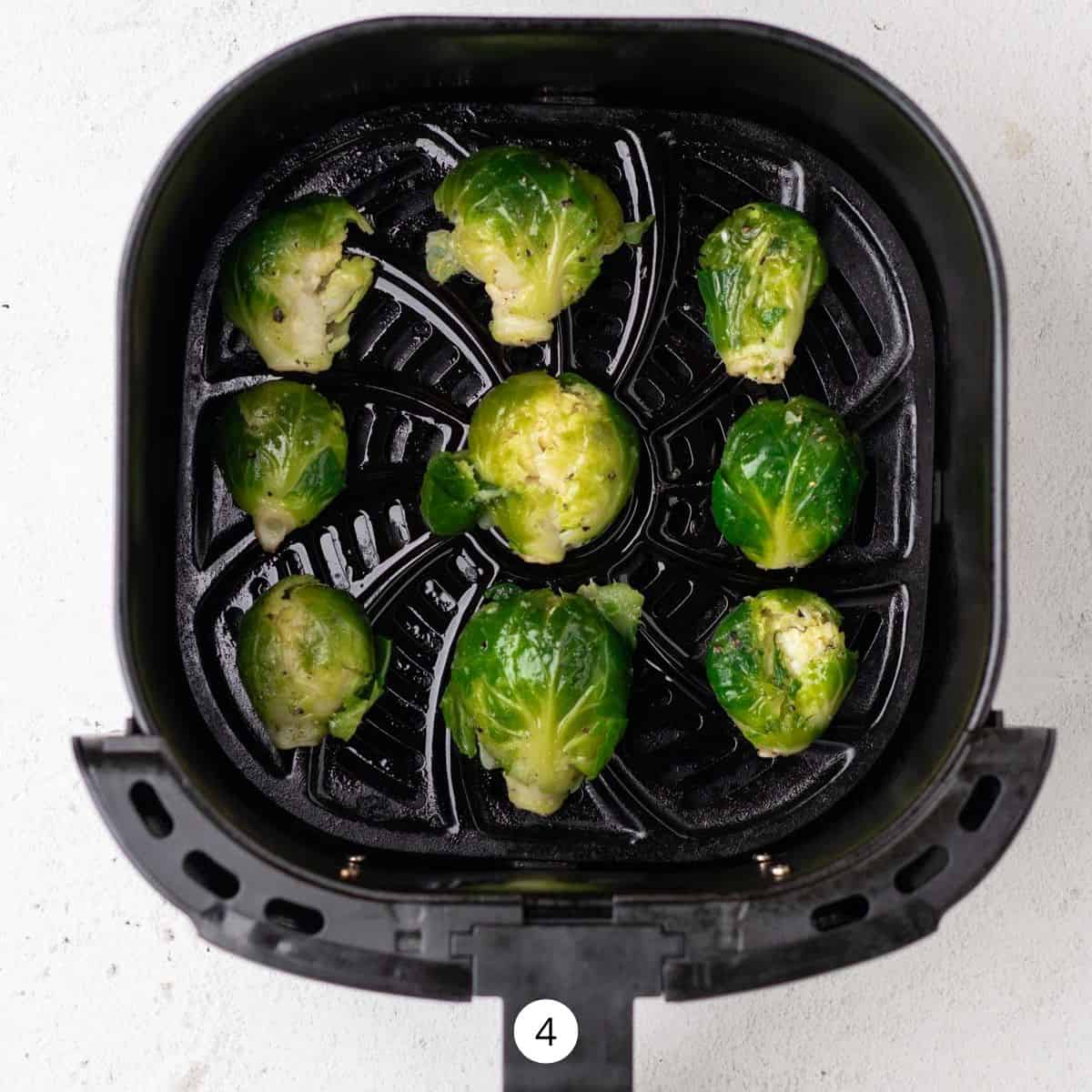 Smashed Brussels Sprouts inside of an air fryer basket.