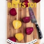 Raw red and yellow beets cut in half lengthwise on a wooden cutting board.