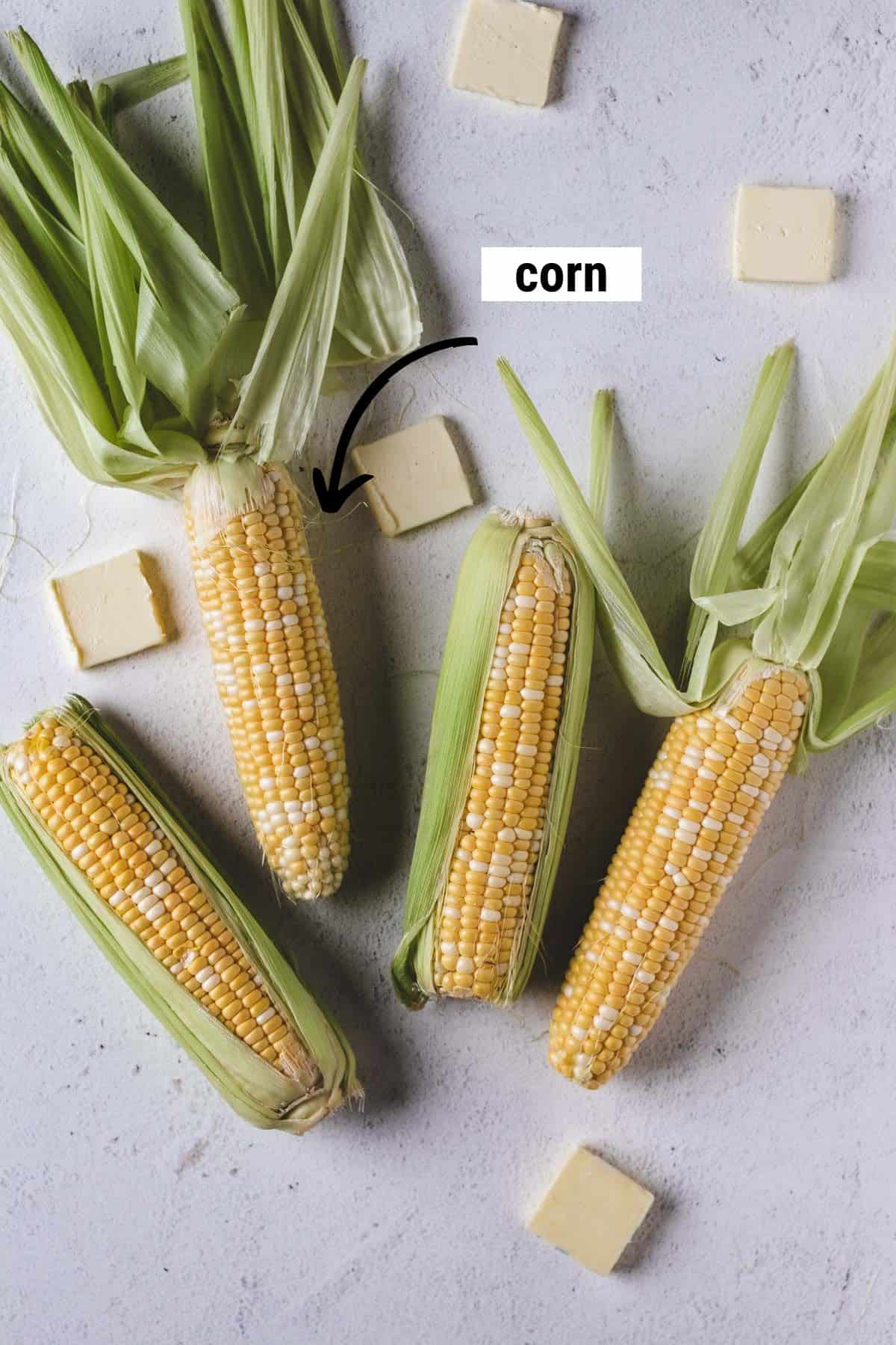 Four ears of corn with slices of butter.