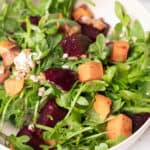 Arugula salad with roasted butternut squash, farro, goat cheese, and beets.