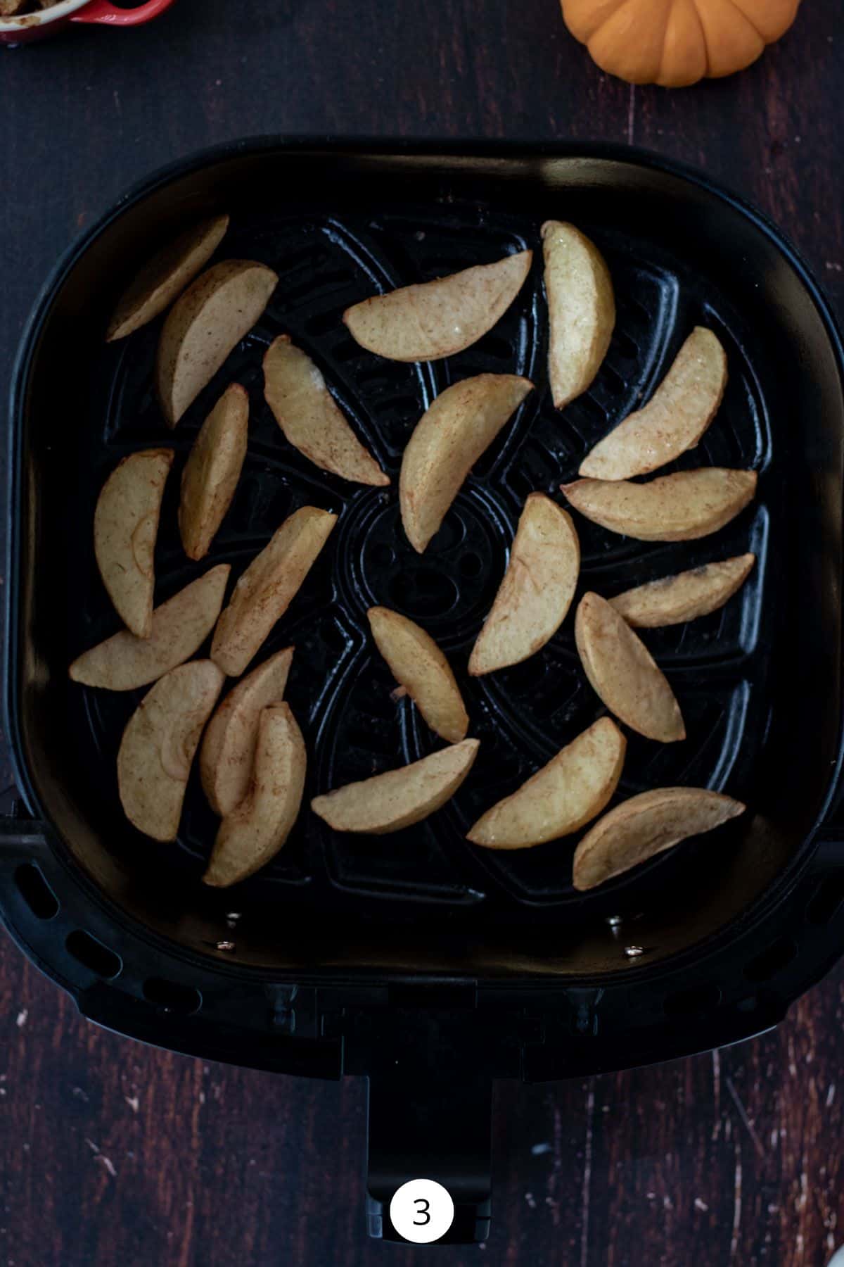 Air fried apples inside of an air fryer basket.