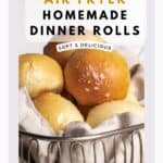 Cooked dinner rolls stacked high inside of a wire bread basket lined with a gray napkin.