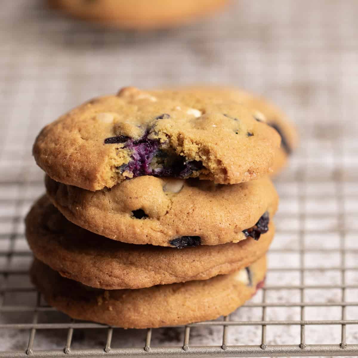 Four cookies stacked on top of each other with a bite bitten out of the top cookie.
