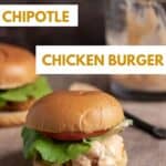 Two air fryer chicken burgers sitting on a wooden cutting board with chipotle sauce in the background.