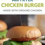 A chicken burger with lettuce, tomato, and chipotle sauce dripping down the edges.