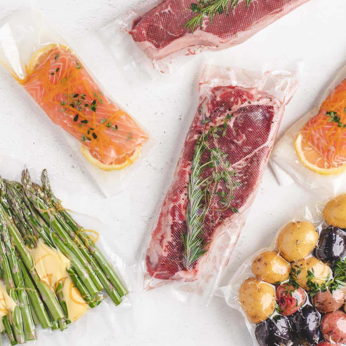Steak, salmon, asparagus, and potatoes vacuum sealed.