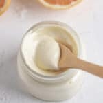 Avocado oil mayo inside of a small glass jar with a mini wooden spoon inside of it.