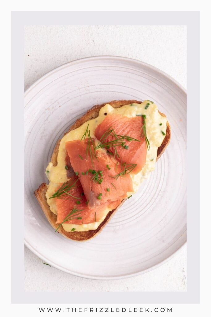 One slice of smoked salmon toast on a large white plate.