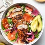 A blackened chicken salad inside of a large-white salad bowl.
