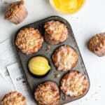 Lemon curd muffins positioned in different angles inside of an old muffin tin.