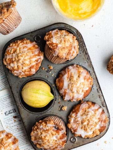 Lemon curd muffins positioned in different angles inside of an old muffin tin.
