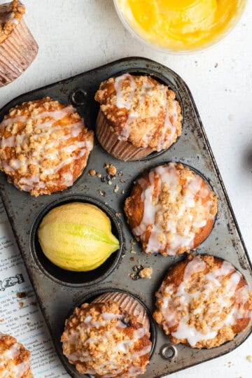 Lemon curd muffins positioned in different angles inside of an old muffin tin.