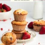 Three strawberry muffins stacked on top of each other on a small tea plate.