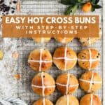 Hot cross buns resting on a wire rack.
