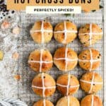 Hot cross buns resting on a wire rack.