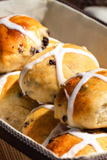 Hot cross buns inside of a bread basket for Easter Brunch.