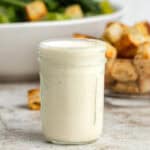 A mason jar filled with a Caesar salad dressing without anchovies.