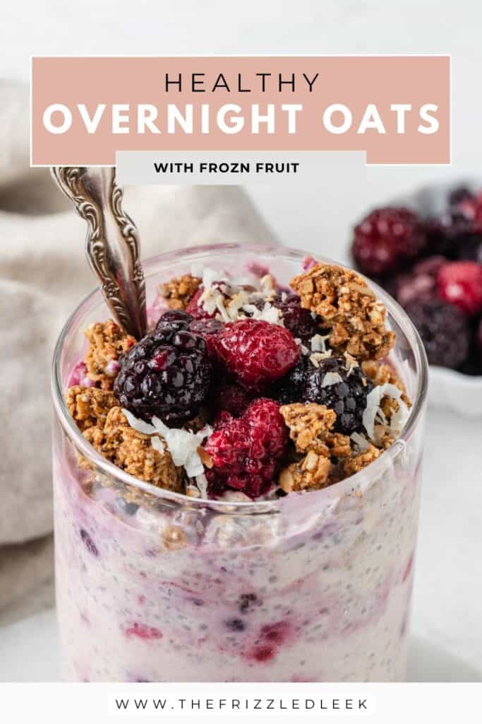 Overnight oats with frozen berries, crunchy granola, and shredded coconut inside of a glass jar.
